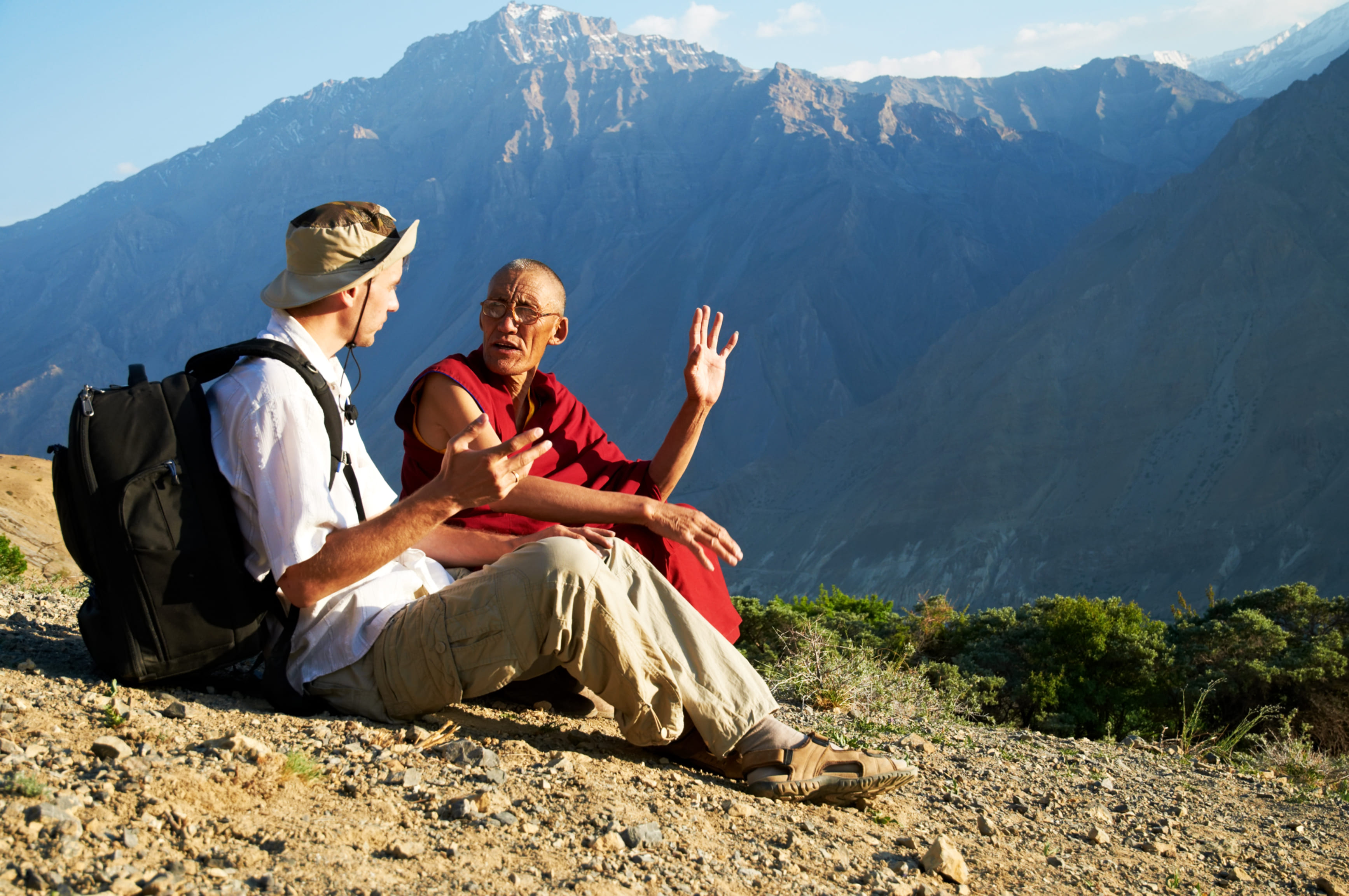 Tourist spricht auf einem Berg mit einem Einheimischen. Reisearten, wie Begegnung, soll hier dargestellt werden. 
