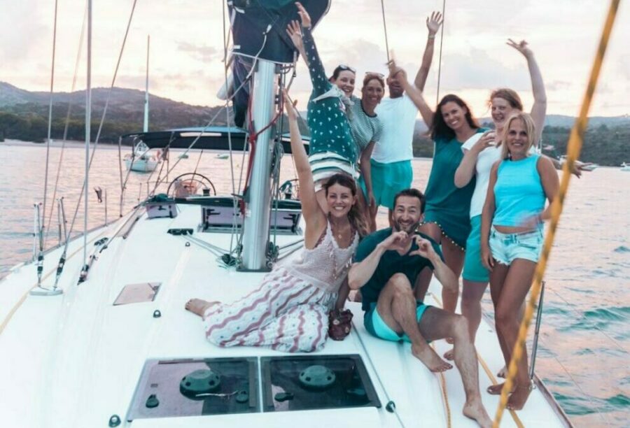 Eine fröhliche Reisegruppe auf einem Segelboot im Mittelmeer