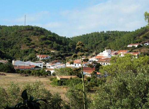 Kleines weißes Dorf in Portugal mit Hügeln im Hintergrund.